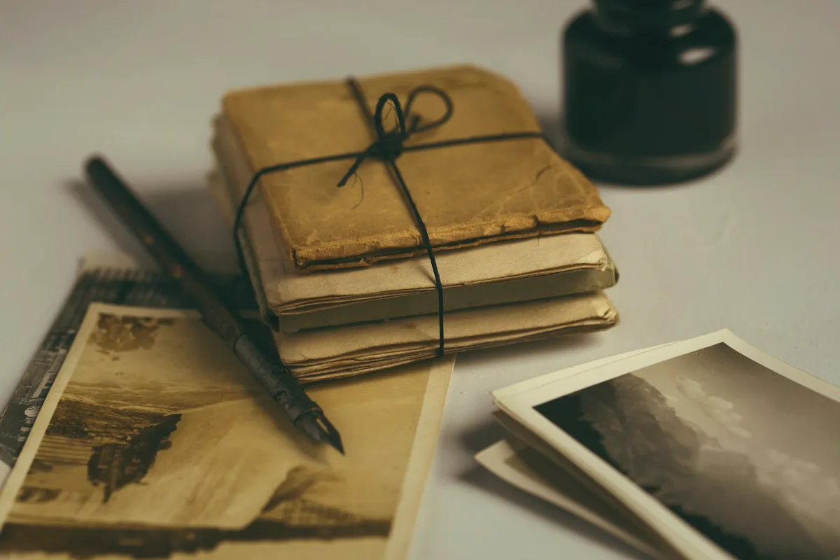 Pile de vieilles lettres nouée d’une ficelle, avec un stylo-plume et des cartes anciennes